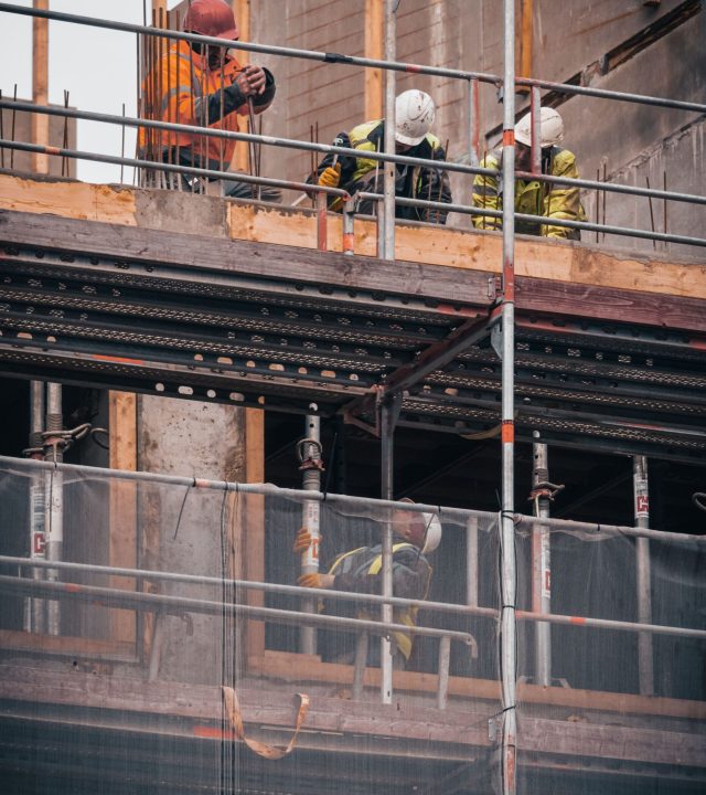 Construction workers engage in building tasks on a scaffold in Hamburg.